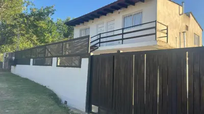 a house with a wooden fence in front of it at Mi casa in Villa Carlos Paz