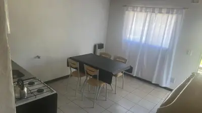 a small kitchen with a black table and chairs at Mi casa in Villa Carlos Paz