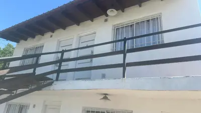 a white building with black railings on the side of it at Mi casa in Villa Carlos Paz