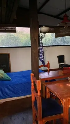 a bedroom with a bed and a table and a table and chairs at Eco Refugio de Montaña en San Javier, Traslasierra in San Javier