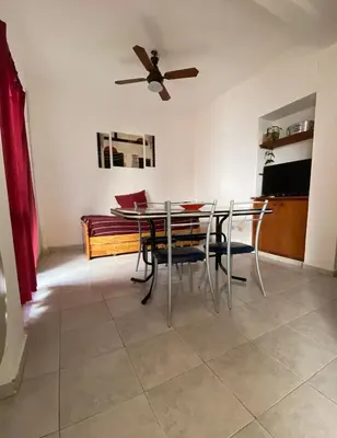 a dining room with a table and chairs and a bed at Depto 1 in Villa Carlos Paz