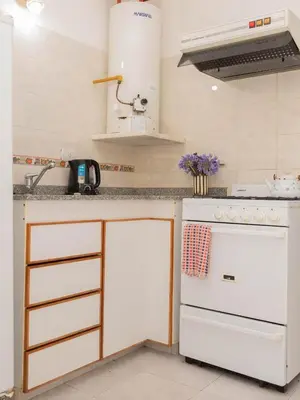 a kitchen with a white stove and a sink at Depto 1 in Villa Carlos Paz