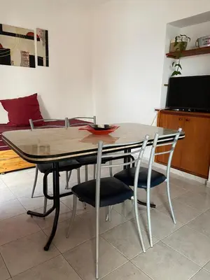 a dining room table with four chairs and a television at Depto 1 in Villa Carlos Paz