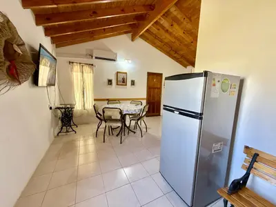 a kitchen with a refrigerator and a table with chairs at Casa Los Prados Mina Clavero in Mina Clavero