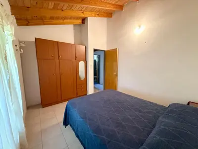 a bedroom with a blue bed and a wooden cabinet at Casa Los Prados Mina Clavero in Mina Clavero