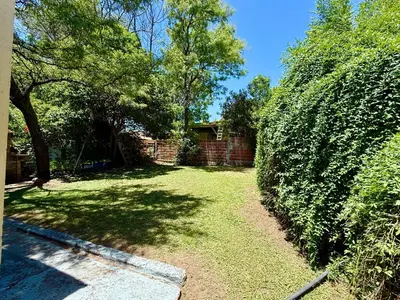 a yard with a hedge and a house at Casa Los Prados Mina Clavero in Mina Clavero