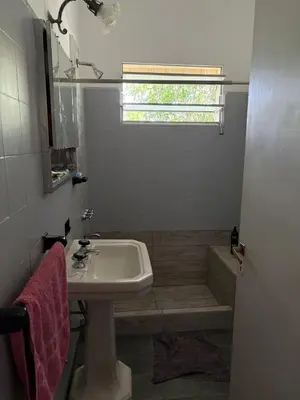 a bathroom with a sink and a tub and a window at Casa centro in Villa Carlos Paz