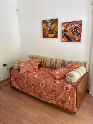 a bed in a room with two paintings on the wall at Casa centro in Villa Carlos Paz