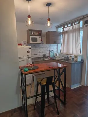 a kitchen with a wooden table and a counter top at Microcentro La Cañada in Cordoba