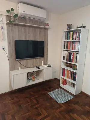 a living room with a television and a book shelf at Microcentro La Cañada in Cordoba