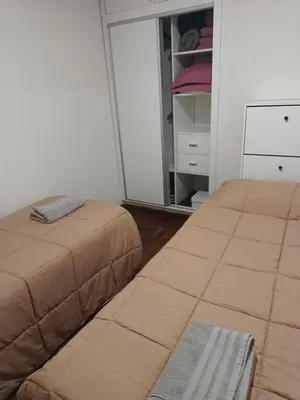 a bedroom with two beds and a closet at Microcentro La Cañada in Cordoba