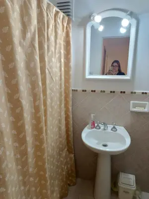 a bathroom with a sink and a shower curtain at Microcentro La Cañada in Cordoba