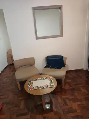 a living room with two chairs and a table at Microcentro La Cañada in Cordoba