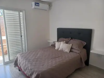 a bedroom with a large bed with two pillows at Alojamiento de lujo , duplex - departamento in Villa Carlos Paz