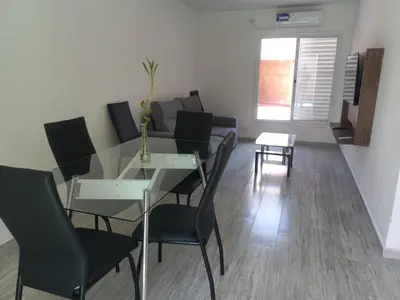 a dining room with a glass table and black chairs at Alojamiento de lujo , duplex - departamento in Villa Carlos Paz