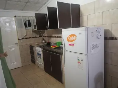 a kitchen with white appliances and brown cabinets at mi casita en tanti, casa 25 in Tanti