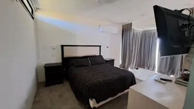 a bedroom with a bed and a flat screen tv at Cabañas Chirivita Atos Pampa in Atos Pampa