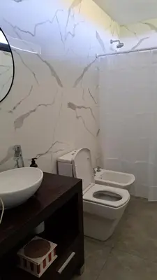 a bathroom with a toilet and a sink at Cabañas Chirivita Atos Pampa in Atos Pampa