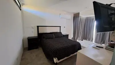 a bedroom with a bed and a flat screen tv at Cabañas Chirivita Atos Pampa in Atos Pampa