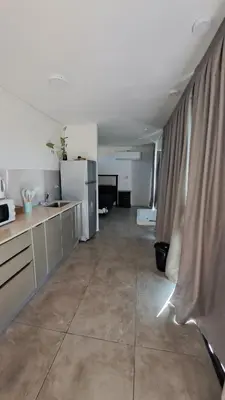 a kitchen with white appliances and a large tile floor at Cabañas Chirivita Atos Pampa in Atos Pampa