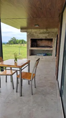 a patio with a table and chairs and a fireplace at Cabañas Chirivita Atos Pampa in Atos Pampa