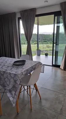 a dining table with two chairs and a view of a room at Cabañas Chirivita Atos Pampa in Atos Pampa