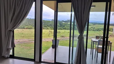 a room with glass doors with a view of a field at Cabañas Chirivita Atos Pampa in Atos Pampa