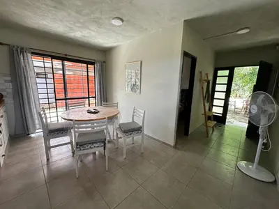a dining room with a table and chairs and a fan at Aires- Casas de campo in Villa Carlos Paz
