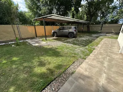a car parked under a cover in a yard at Aires- Casas de campo in Villa Carlos Paz