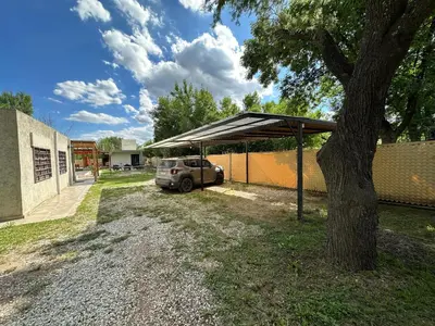 a car parked under a canopy next to a tree at Aires- Casas de campo in Villa Carlos Paz