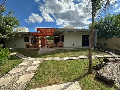 a house with a garden and a patio at Aires- Casas de campo in Villa Carlos Paz