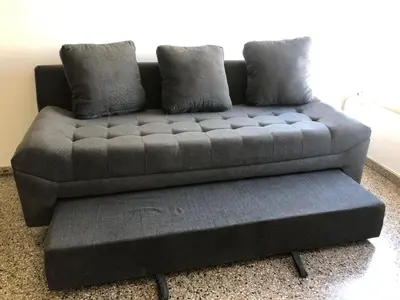 a couch with two pillows on top of a ottoman at Temporario Nebwery Villa Carlos Paz in Villa Carlos Paz