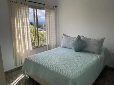 a bed with two pillows in a room with a window at Temporario Nebwery Villa Carlos Paz in Villa Carlos Paz