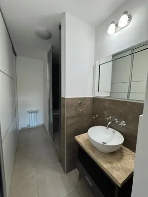 a bathroom with a white sink and a shower at Dpto a estrenar Villa Carlos Paz frente a la costanera in Villa Carlos Paz