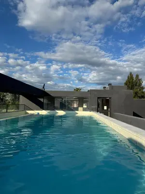 a swimming pool in front of a house at Dpto a estrenar Villa Carlos Paz frente a la costanera in Villa Carlos Paz