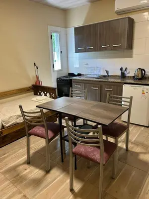 a kitchen with a table and chairs in a kitchen at El Atardecer in Trapiche