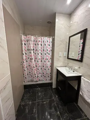 a bathroom with a shower with a sink and a mirror at El Atardecer in Trapiche