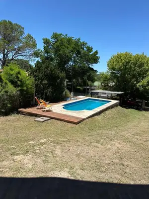 a swimming pool in a yard with a chair next to it at La Casa de Aromas del Valle in Santa Rosa de Calamuchita