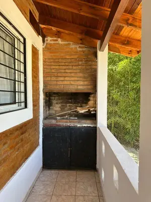 an outside entrance to a house with a black door at La Casa de Aromas del Valle in Santa Rosa de Calamuchita