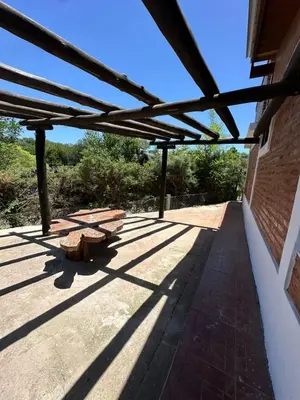 a patio with benches on the side of a building at La Casa de Aromas del Valle in Santa Rosa de Calamuchita