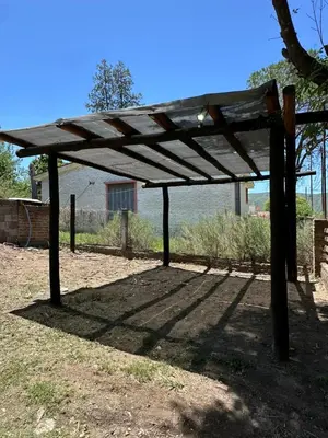 a wooden pergola sitting on top of a field at La Casa de Aromas del Valle in Santa Rosa de Calamuchita
