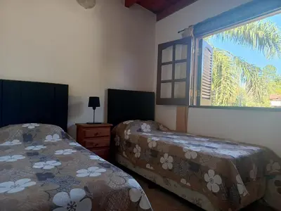 a bedroom with two beds and a window at Complejo Albox in Villa Carlos Paz