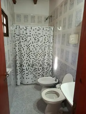 a bathroom with a toilet and a shower curtain at Complejo Albox in Villa Carlos Paz