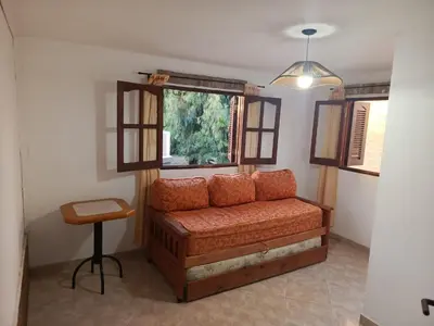 a living room with a couch and a window at Complejo Albox in Villa Carlos Paz