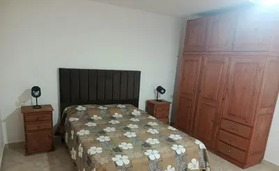 a bedroom with a bed and two wooden cabinets at Complejo Albox in Villa Carlos Paz