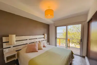a bedroom with a bed and a large window at PUEBLO CHICO - casas de lago in Villa Ciudad de America