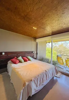 a bedroom with a bed and a large window at PUEBLO CHICO - casas de lago in Villa Ciudad de America