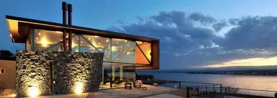 a large glass building with a view of the water at PUEBLO CHICO - casas de lago in Villa Ciudad de America