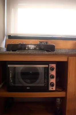 a microwave on a wooden stand with a tv at Departamento Córdoba Centro in Cordoba