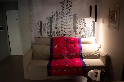 a living room with a couch with a red blanket at Departamento Córdoba Centro in Cordoba